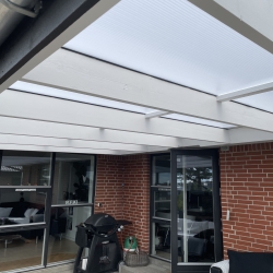 Hus med terrasseoverdækning og sort nyt tag af tømrer