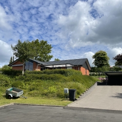 Hus set fra afstand med ny tagrenovering og tømrerarbejde