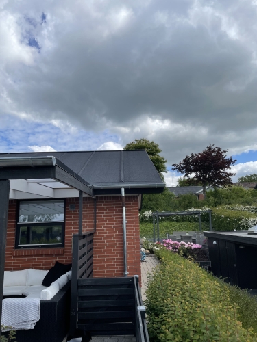Hjørne af hus med tagrenovering lavet af tømrer