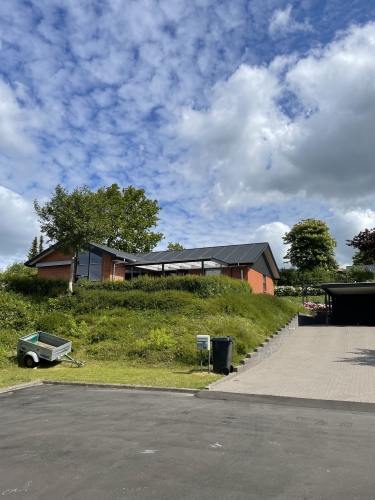 Hus set fra afstand med ny tagrenovering og tømrerarbejde
