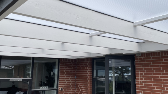Hus med terrasseoverdækning og sort nyt tag af tømrer