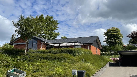 Hus set fra afstand med ny tagrenovering og tømrerarbejde