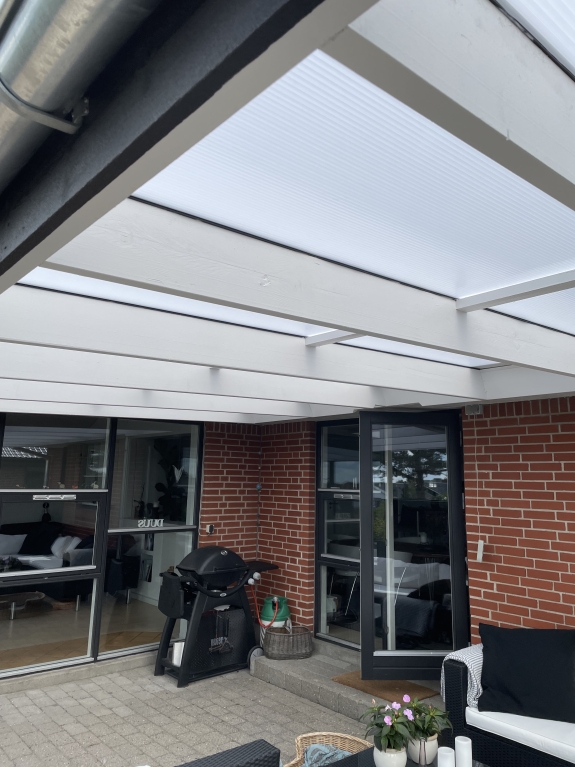 Hus med terrasseoverdækning og sort nyt tag af tømrer