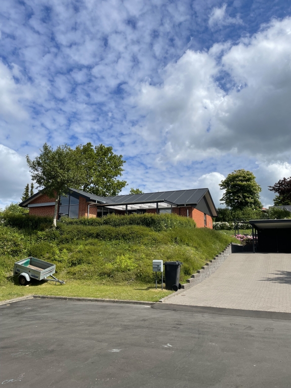 Hus set fra afstand med ny tagrenovering og tømrerarbejde
